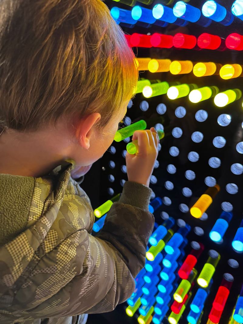 Back of child's head pressing colourful buttons