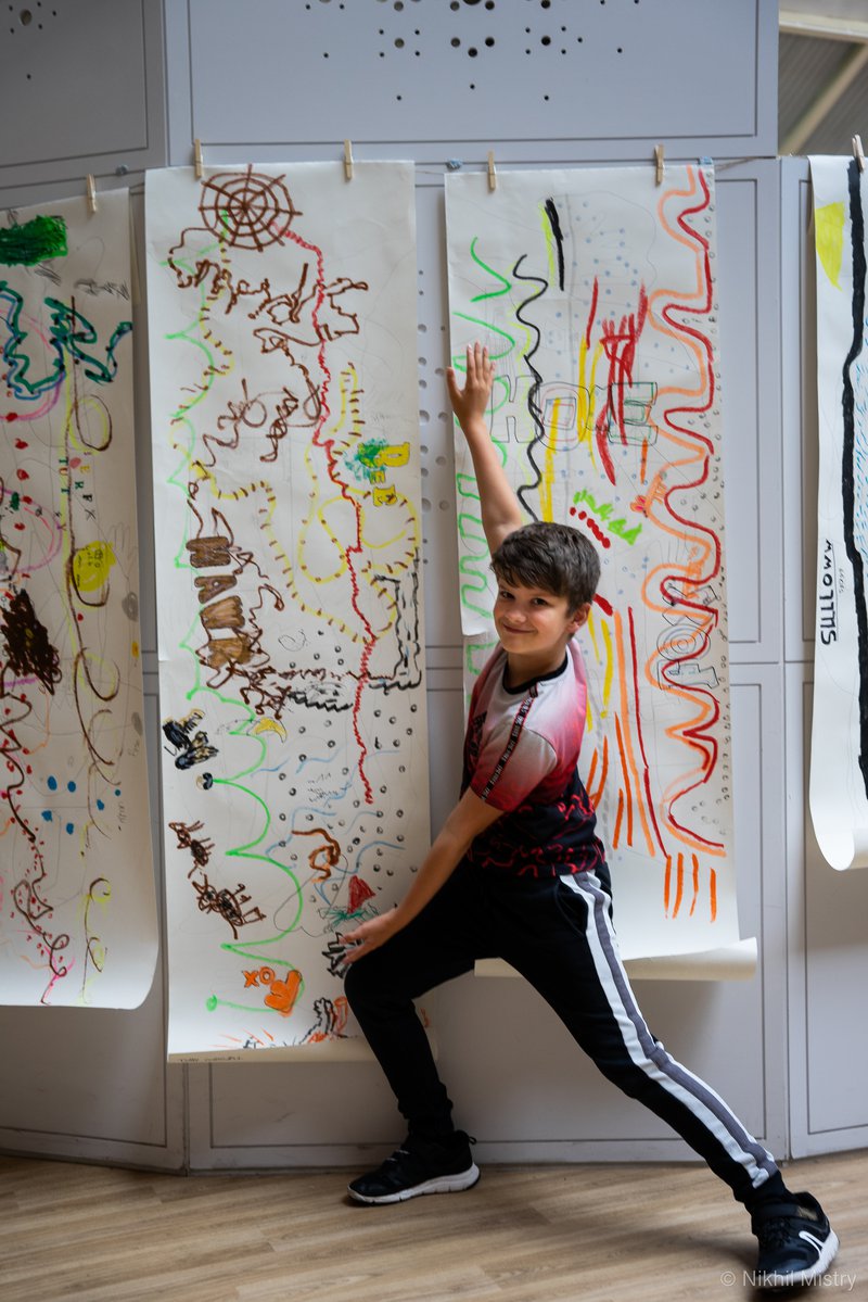 Young boy posing infront of his artwork