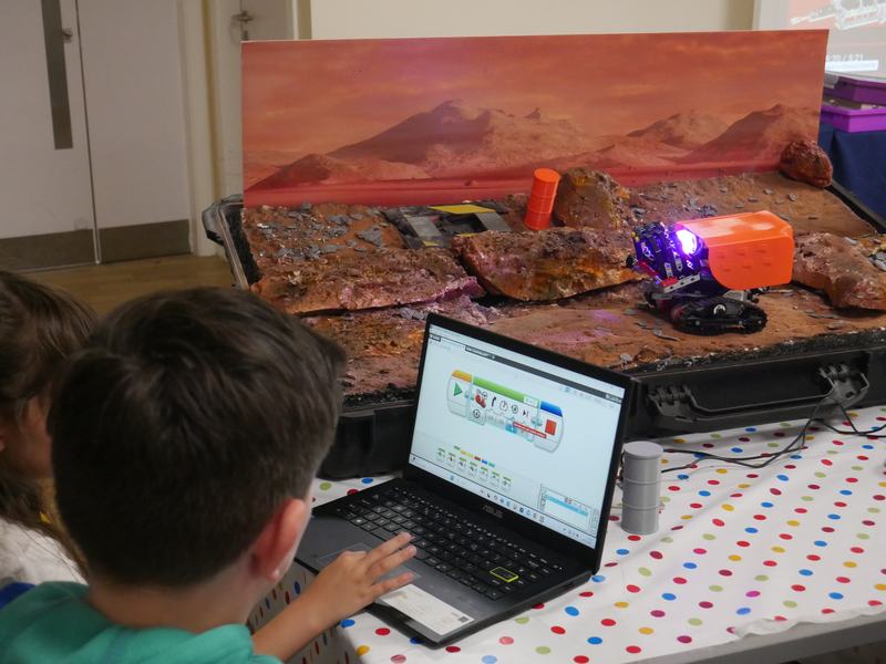 Child doing coding activity infront of Mars surface model