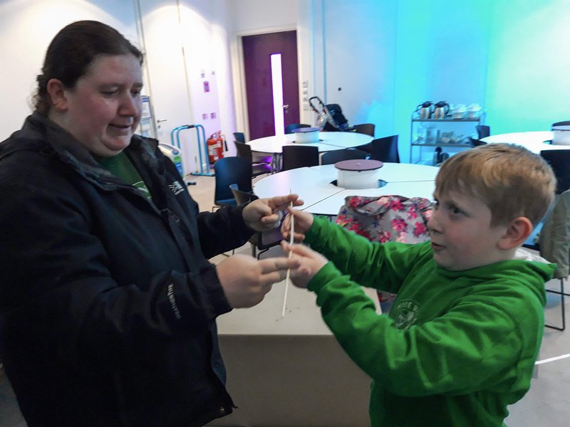 An adult and child stood in a classroom working on an experiment together.