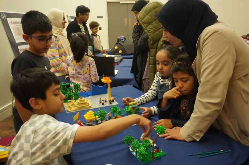 A woman and three boys playing an activity