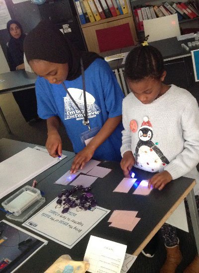 Two young people stood working at a table together.