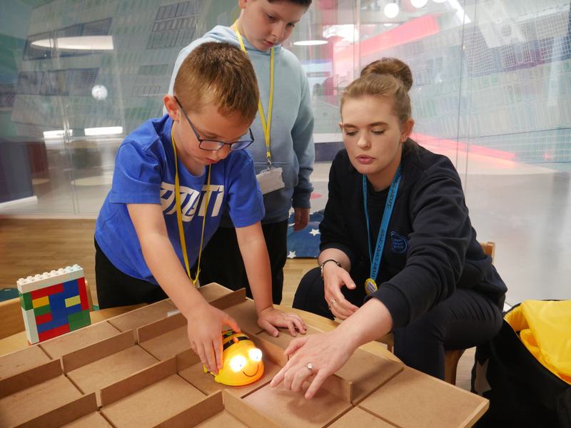 Child and adult playing with a Beebot in a maze