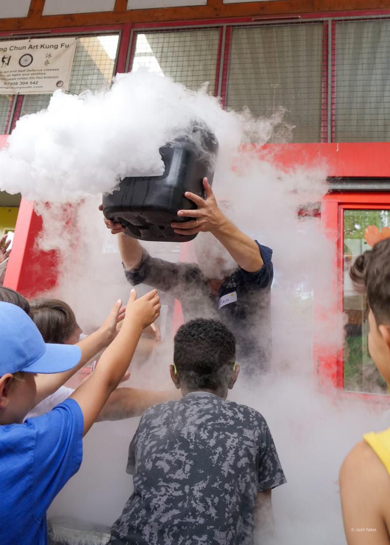 Children reaching towards smoke coming from an experiment